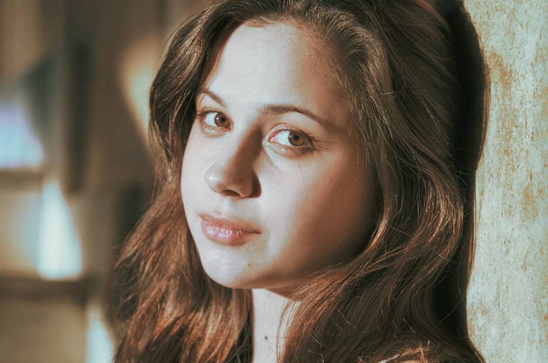 Portrait of a young woman with long brown hair smiling